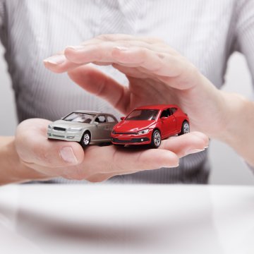 review autopom! extended car warranty man holding red and gray toy cars in hands